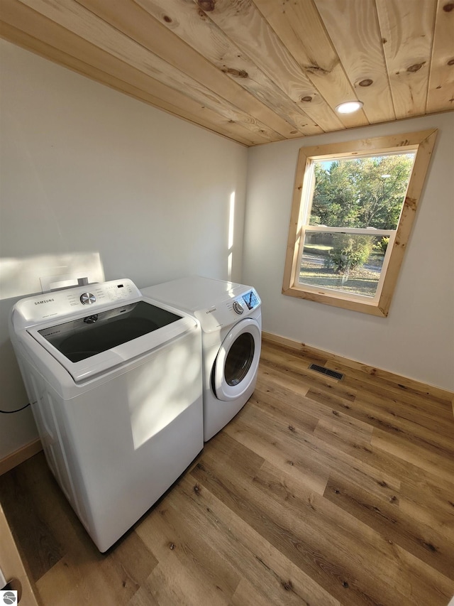 washroom with washer and clothes dryer, light hardwood / wood-style floors, and wooden ceiling