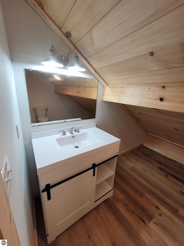 bathroom with wood ceiling, vanity, lofted ceiling, hardwood / wood-style flooring, and toilet