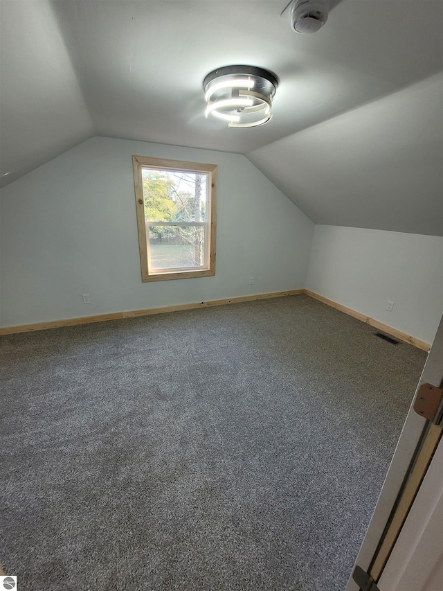 bonus room with carpet flooring and vaulted ceiling