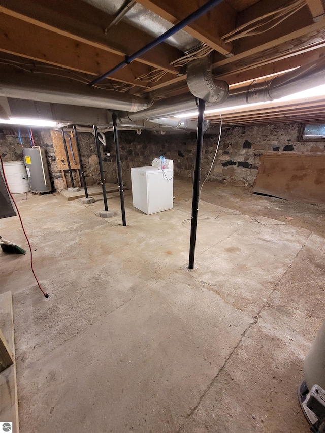 basement with water heater and washer and clothes dryer