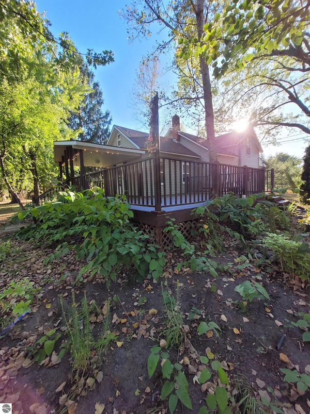 rear view of house featuring a wooden deck