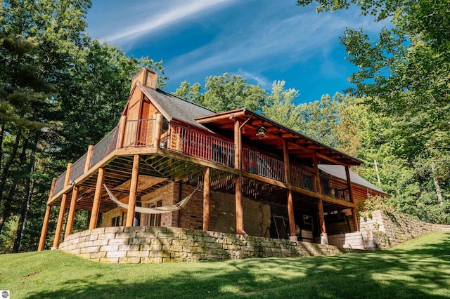 rear view of house featuring a yard, a wooden deck, and a patio area