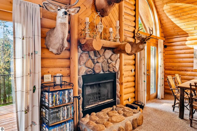 living room featuring wood ceiling, lofted ceiling, carpet flooring, a stone fireplace, and log walls