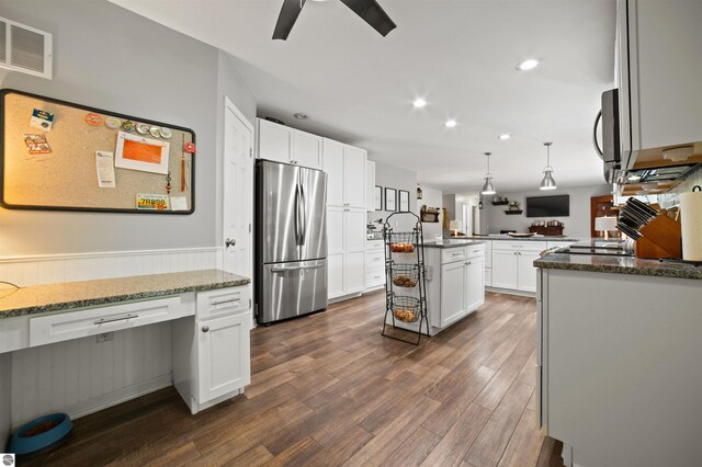 kitchen with a center island, dark hardwood / wood-style floors, white cabinets, stainless steel appliances, and stone countertops