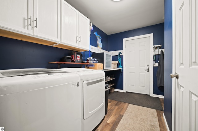 washroom with cabinets, washing machine and dryer, and dark hardwood / wood-style flooring