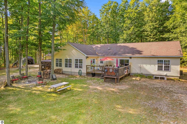 rear view of house featuring a yard and a wooden deck