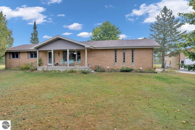 ranch-style home featuring a porch and a front lawn