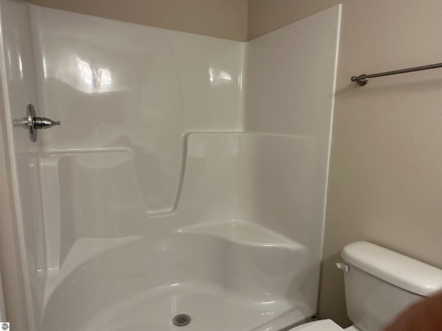 bathroom featuring a shower and toilet