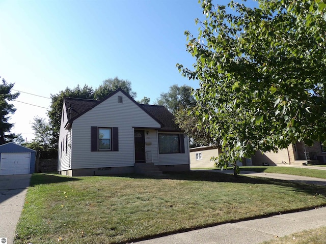 bungalow featuring an outbuilding, a garage, and a front yard