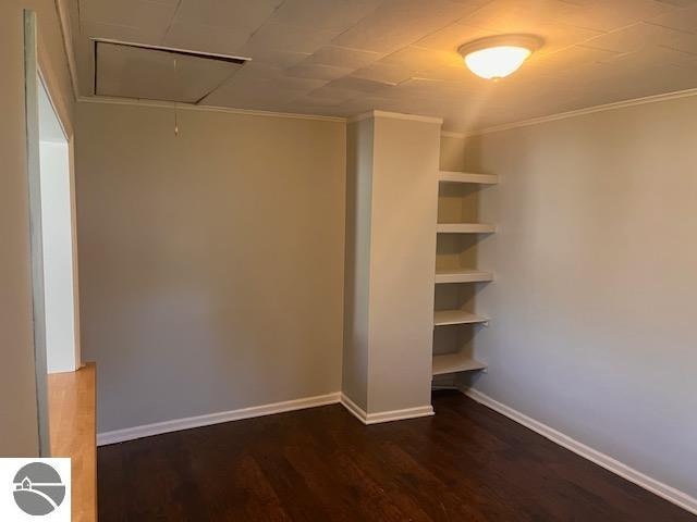 interior space with dark hardwood / wood-style floors and crown molding