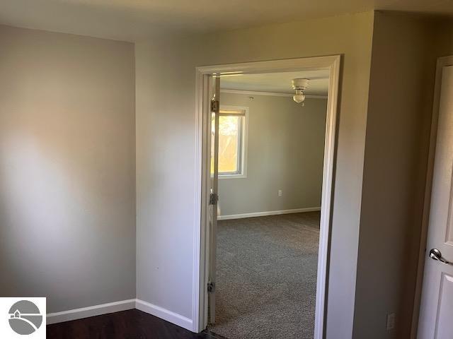 hall with dark colored carpet