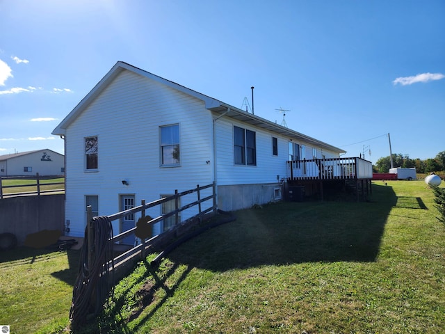 rear view of house featuring a yard and a deck