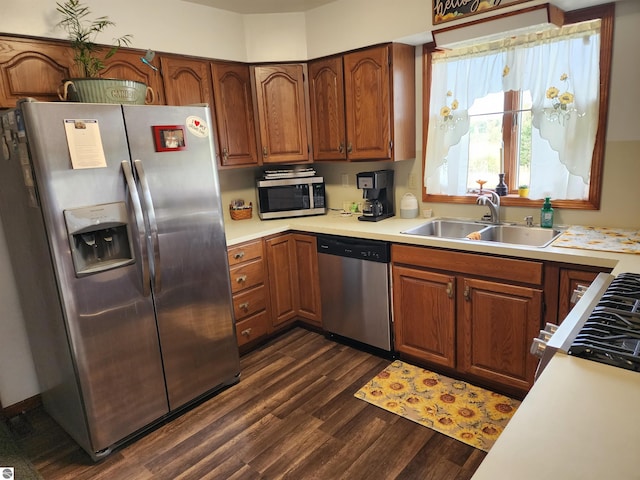 kitchen with stainless steel appliances, dark wood-type flooring, and sink