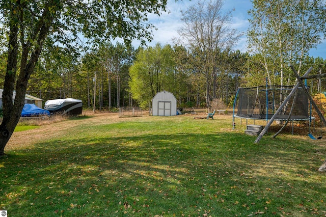 view of yard featuring a trampoline and a shed