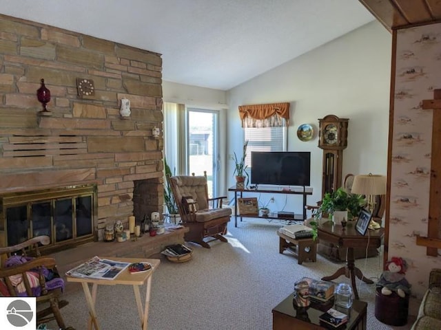 living room with a stone fireplace, lofted ceiling, and carpet flooring