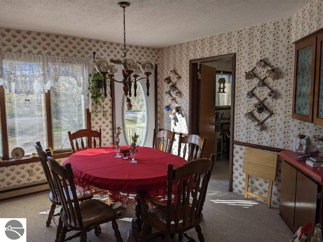 dining room featuring a textured ceiling, carpet flooring, and a chandelier