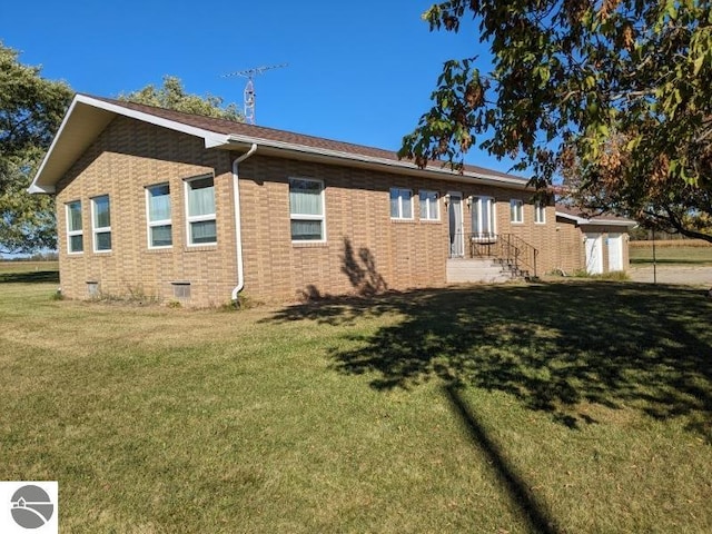 view of side of home featuring a yard and a storage unit