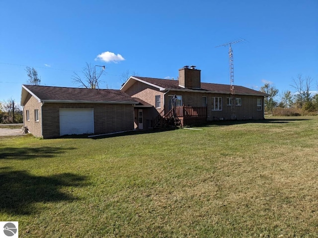 rear view of property with a lawn and a garage