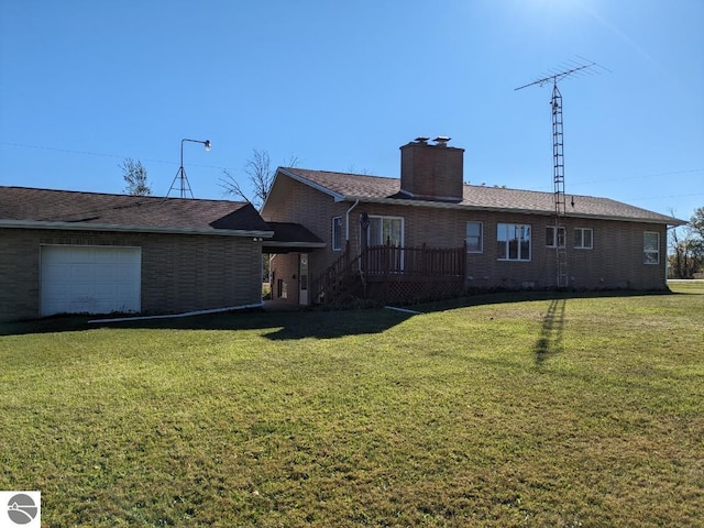 back of property with a lawn and a garage