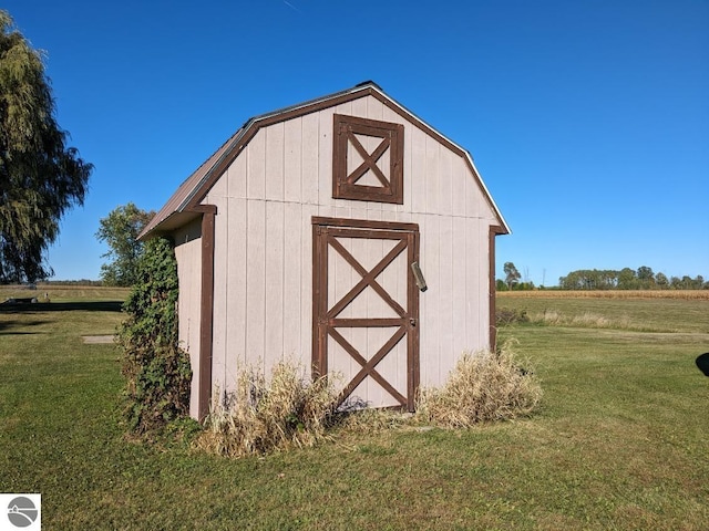 view of outbuilding featuring a rural view and a yard