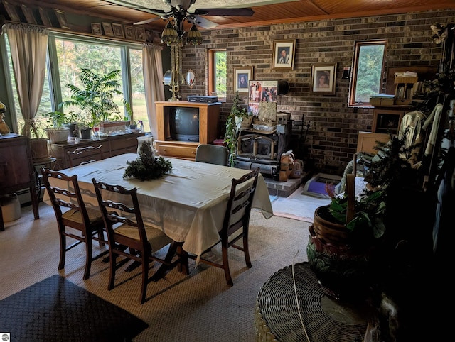 dining space featuring a wood stove, brick wall, and light carpet