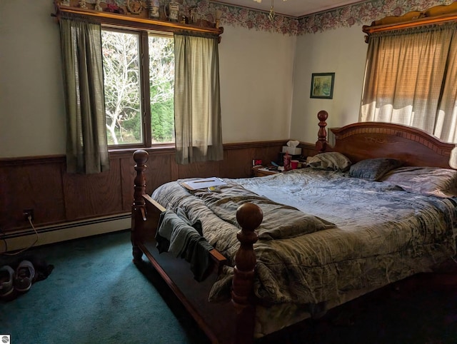 bedroom featuring wooden walls, a baseboard radiator, and carpet floors