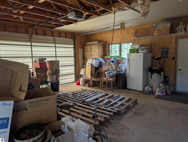 garage featuring a garage door opener and white fridge