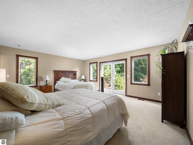 bedroom with light colored carpet and a textured ceiling