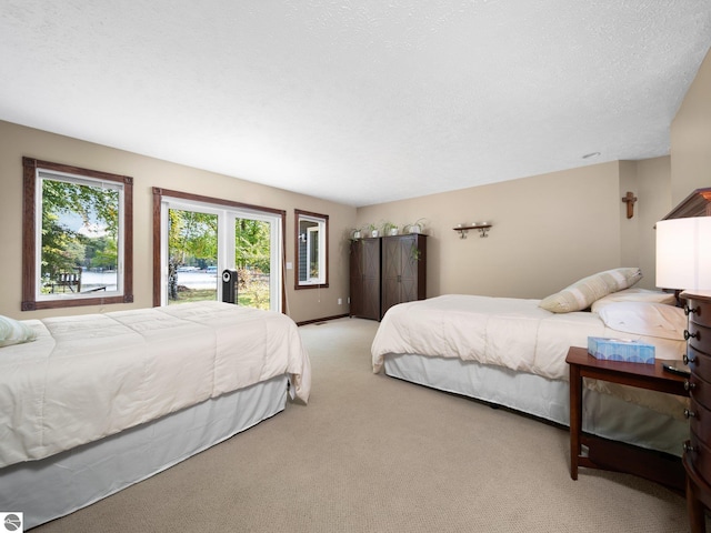 carpeted bedroom featuring access to outside and a textured ceiling