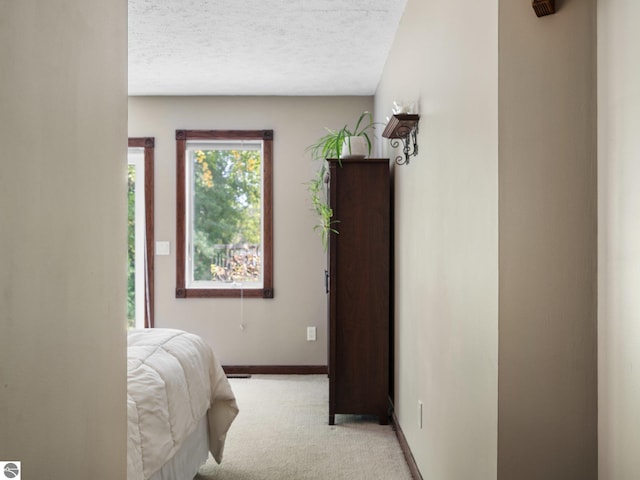 bedroom with light colored carpet and a textured ceiling