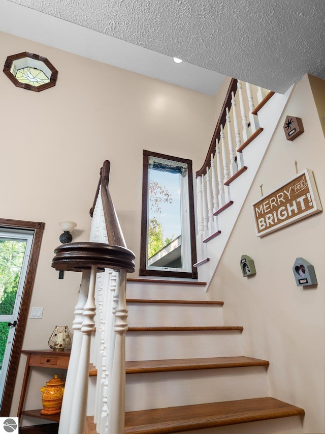 staircase with a textured ceiling