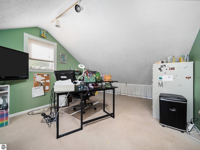 carpeted office space with vaulted ceiling, rail lighting, and a textured ceiling