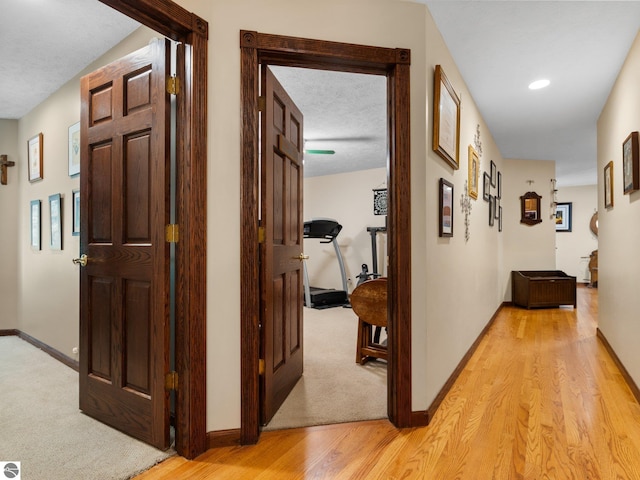 hall featuring light hardwood / wood-style floors and a textured ceiling