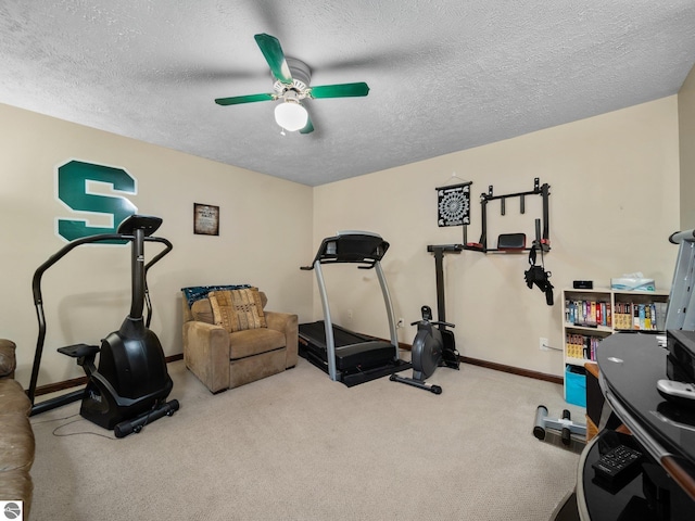 exercise room with ceiling fan, carpet, and a textured ceiling