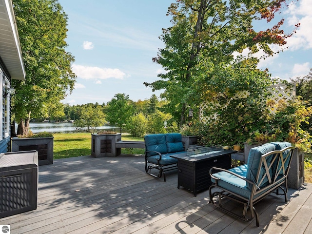 wooden deck featuring a water view and an outdoor living space with a fire pit