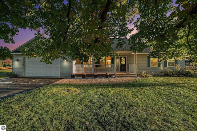 view of front of property with a garage, a yard, and covered porch