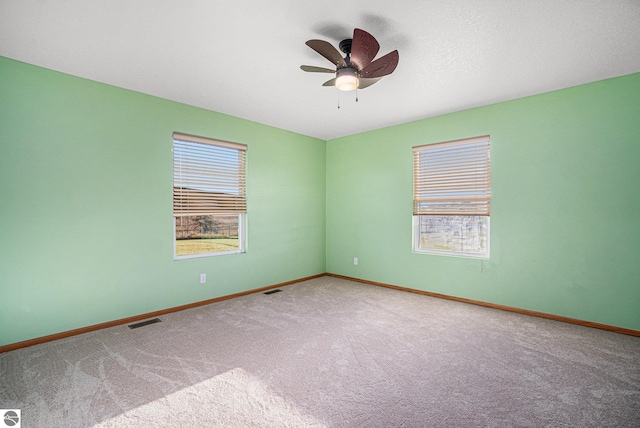 carpeted empty room featuring ceiling fan