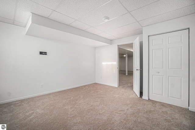 unfurnished bedroom with carpet floors, a closet, and a drop ceiling