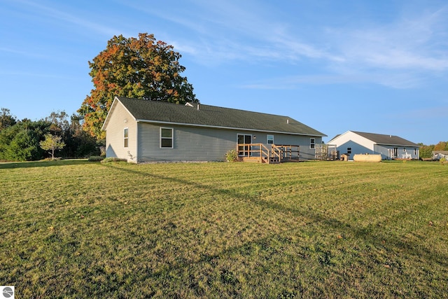 back of house with a wooden deck and a yard