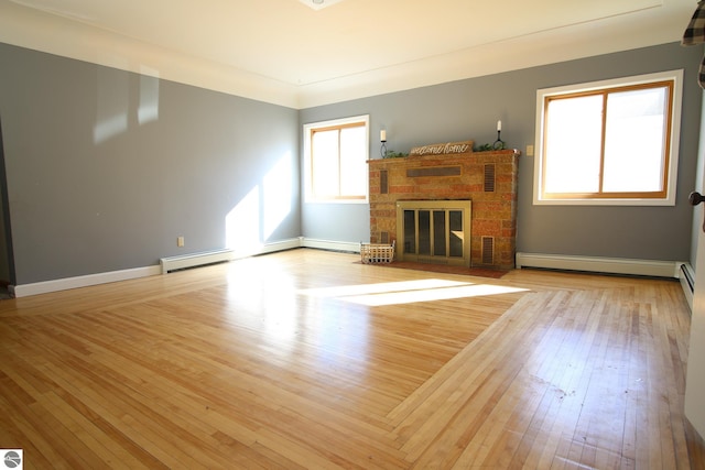 unfurnished living room featuring light wood-type flooring and baseboard heating