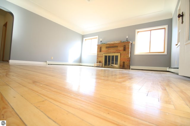 unfurnished living room featuring a fireplace and light hardwood / wood-style floors