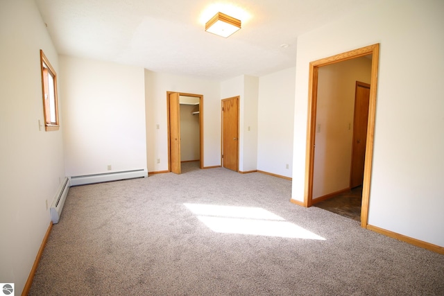 unfurnished bedroom featuring carpet floors, a closet, and a baseboard heating unit