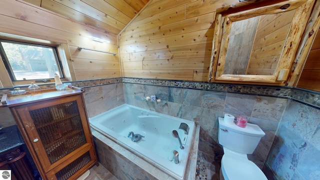 bathroom featuring toilet, a relaxing tiled tub, wood walls, and vaulted ceiling