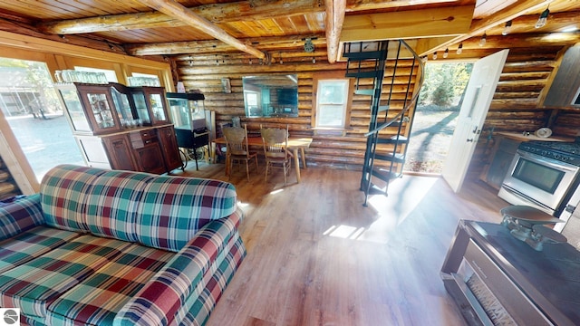 living room featuring light hardwood / wood-style floors, wood ceiling, beamed ceiling, and rustic walls