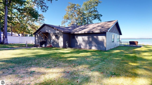 view of front of house with a front yard and a water view