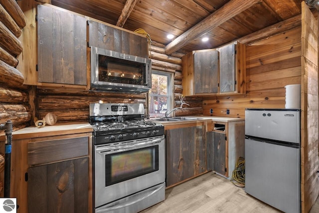 kitchen with wood ceiling, beam ceiling, stainless steel appliances, sink, and light hardwood / wood-style floors