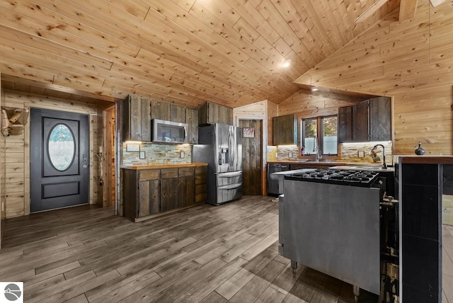 kitchen featuring appliances with stainless steel finishes, light hardwood / wood-style flooring, wooden ceiling, and wood walls