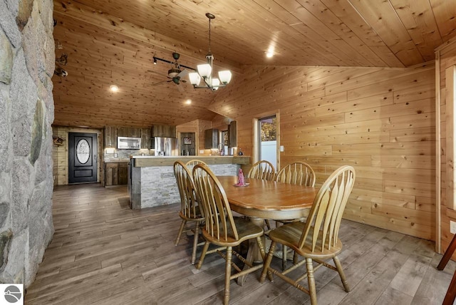 dining room with a notable chandelier, wood ceiling, hardwood / wood-style flooring, and wooden walls