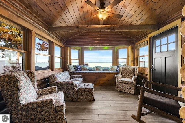 sunroom / solarium featuring vaulted ceiling with beams, a healthy amount of sunlight, and wooden ceiling