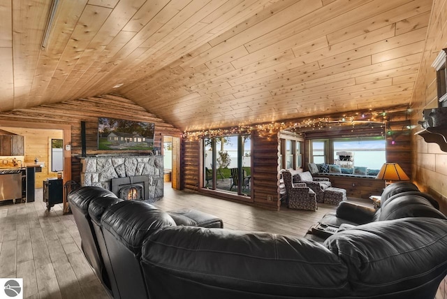 living room with wood-type flooring, wood ceiling, a stone fireplace, lofted ceiling, and wooden walls